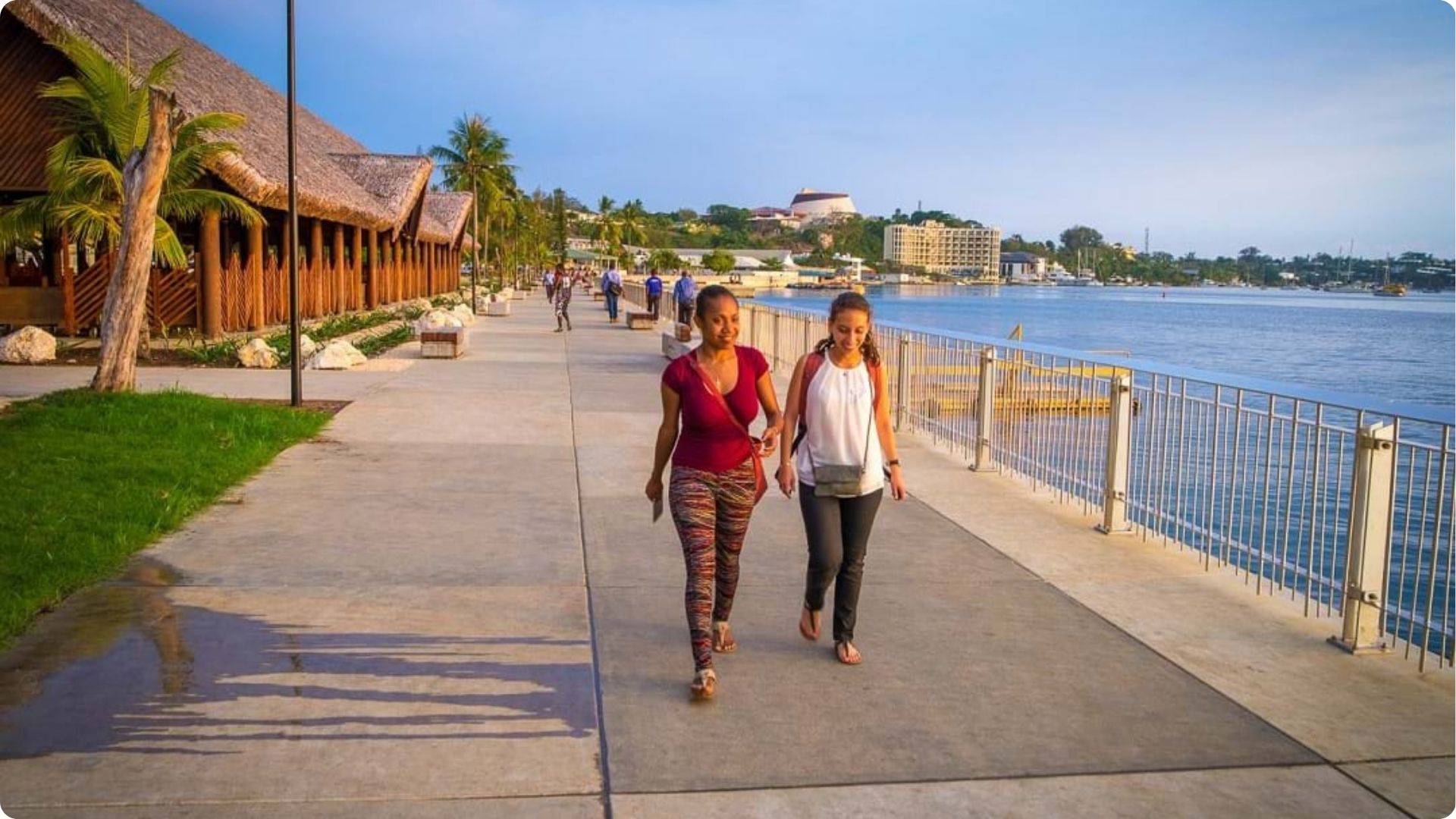 Two people walking along the Efate waterfront