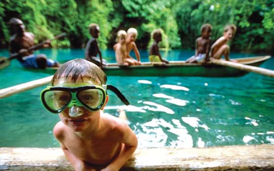 A child snorkelling in the clear waters on the Blue Holes