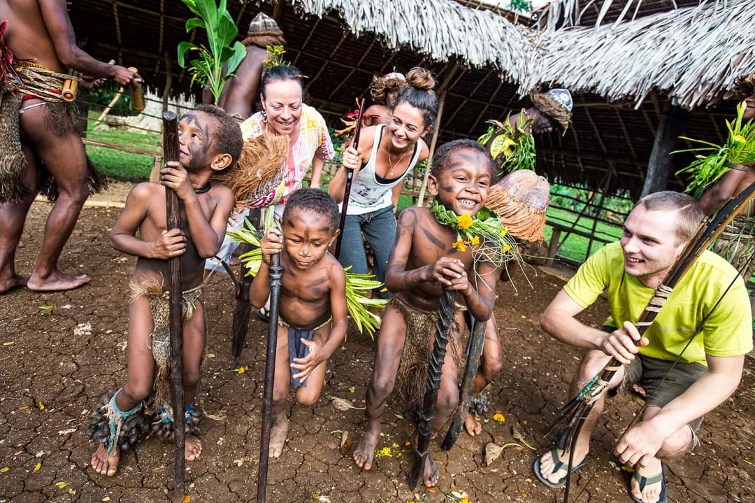 A group of travellers dancing with children from a village in Sola