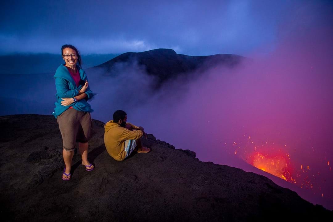 Two people standing on the summit of My Yasur